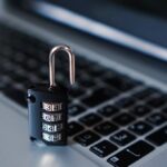 Számzáras lakat egy laptop billentyűzetén, digitális biztonság jelképe